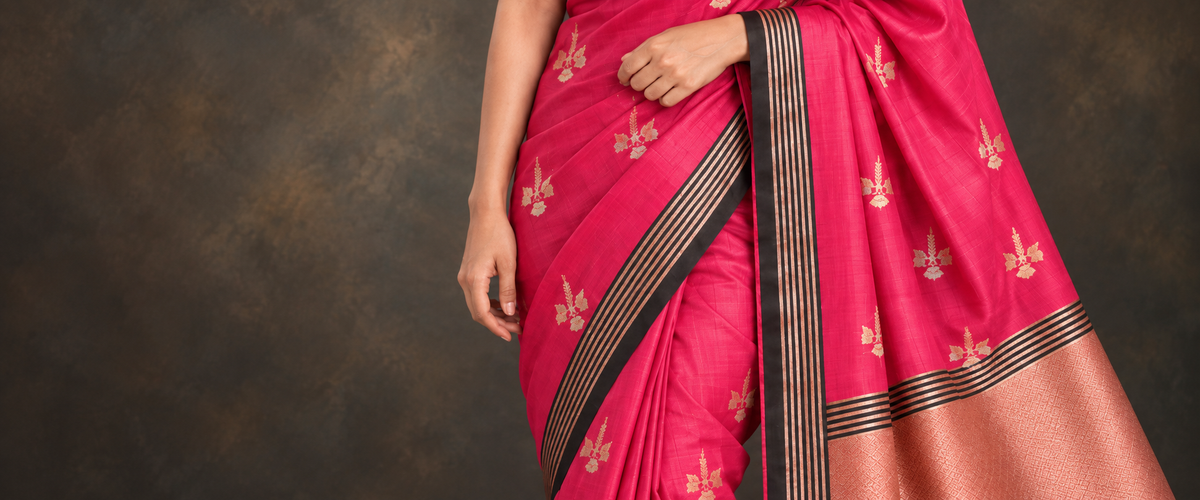 Close view of Gulrang pink silk, floral booti, black and gold border and woven pallu